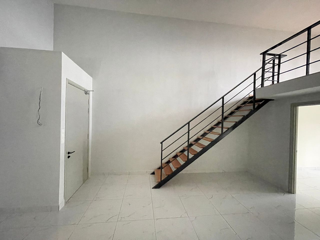 Interior of the unit showing the mezzanine loft level and internal staircase